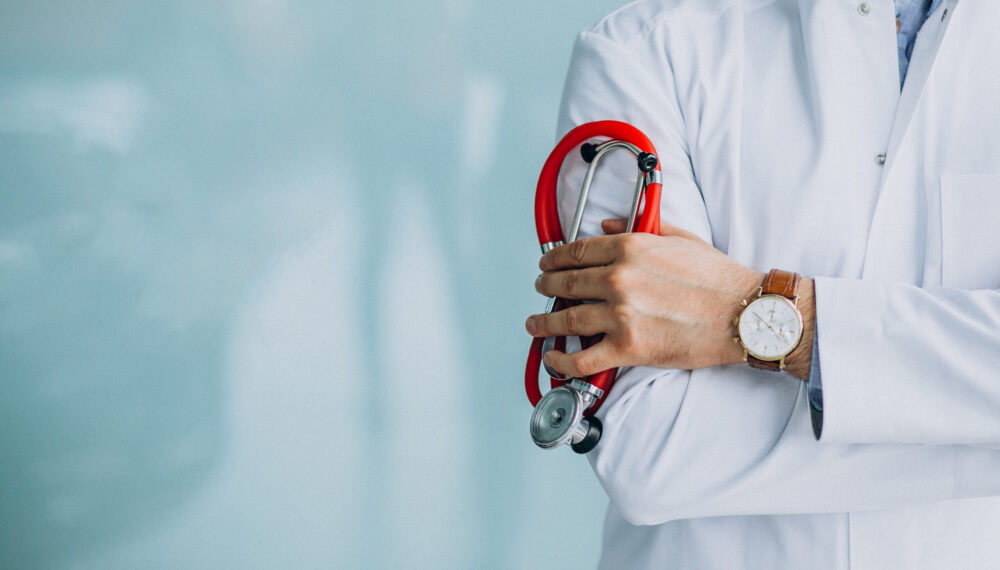 Young handsome physician in a medical robe with stethoscope